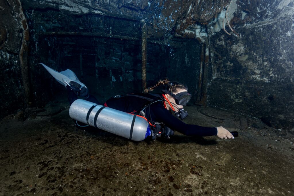 woman on a diving excursion wearing scuba diving gear in a sidemount configuration